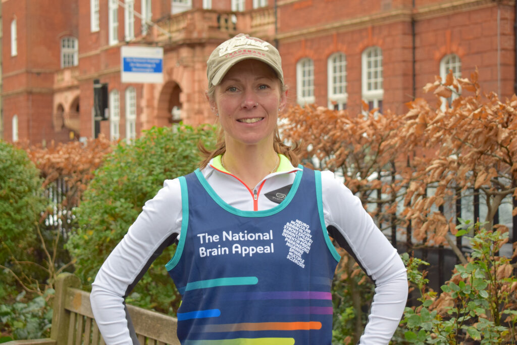 Sarah Dolling in National Brain Appeal running best with cap on, smiling at the camera