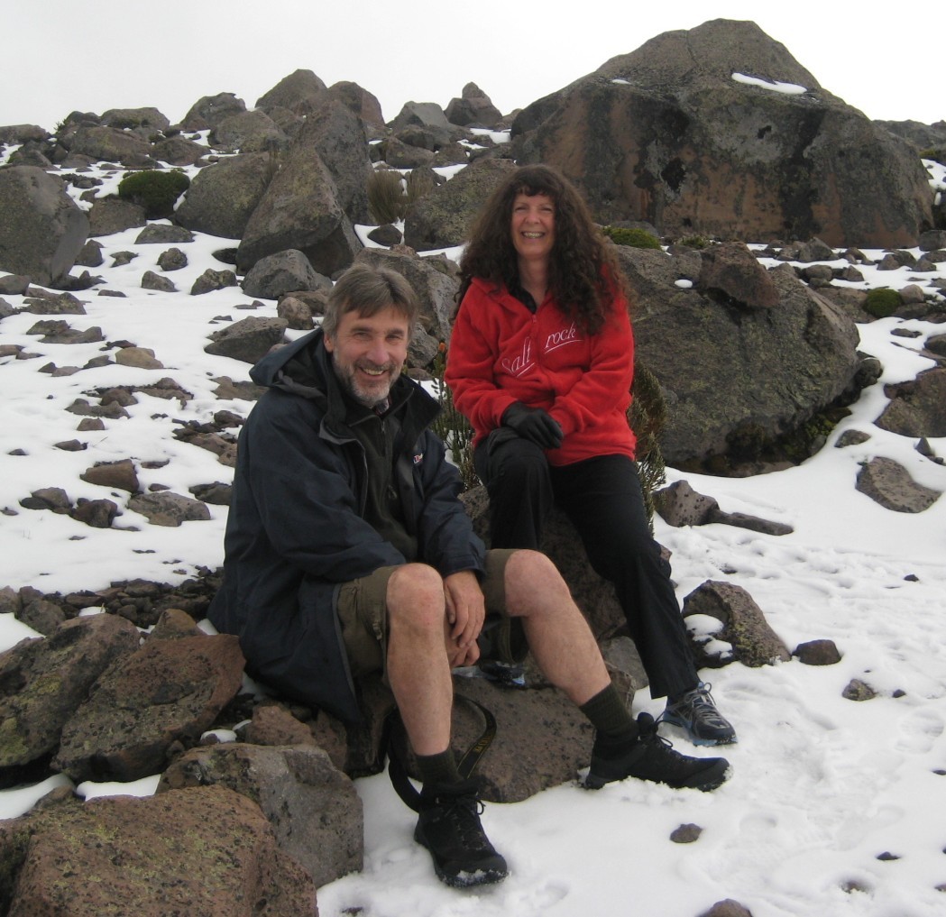 Christopher and Sue Bailes sitting on rocks in the snow.