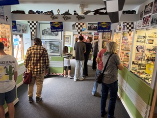 A good turnout at the museum. People are photographed looking into the glass cases filled with toy cars and memorabilia.