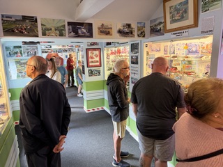 A good turnout at the museum. People are photographed looking into the glass cases filled with toy cars and memorabilia.